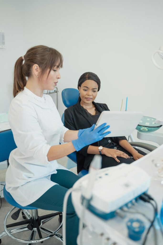 Dentist consulting patient using a tablet in a modern dental clinic.